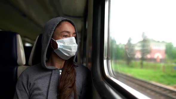 A Close-up Portrait of a Dark-haired, Middle-aged Woman Wearing a Medical Mask and a Hooded