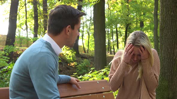 A Couple Argues on a Bench in a Park on a Sunny Day - Closeup