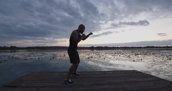 A Man Sharpens His Strokes While Playing Sports on the River Bank