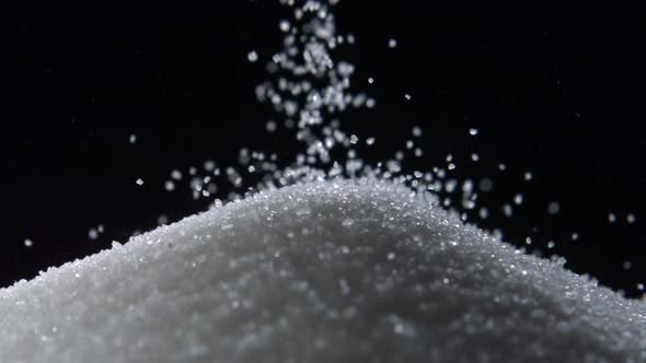 Pile of sugar on black background, Slow Motion alt