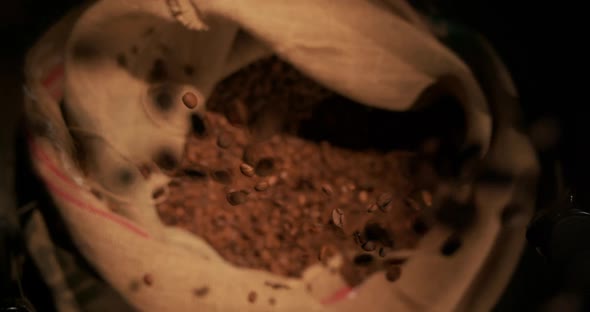 Close Up Seeds of Coffee Fly in Bag and Spin on Black Background Super Slow Motion