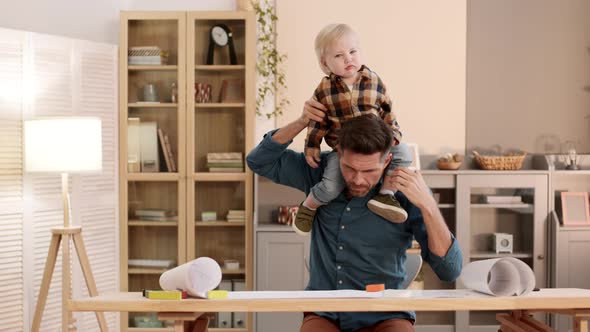 Architect Working with Toddler on Shoulders