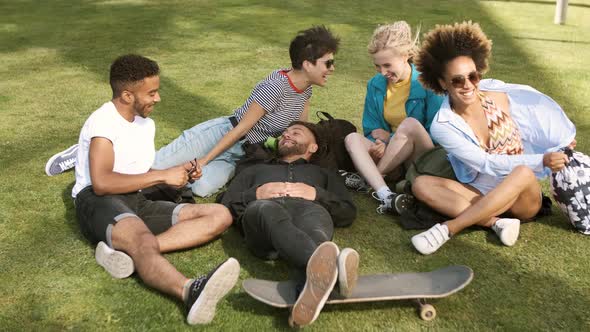 Lounging Friends on Meadow in Park 