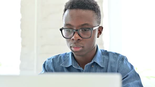 Portrait of Excited Young African Man Celebrating Success on Laptop