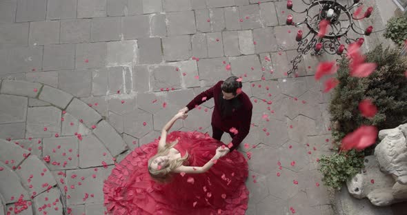 Girl And Guy Stand In Festive Attire And Rose Petals Fly From Above