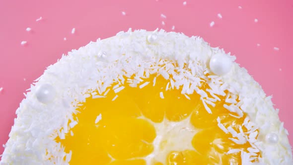 Cake with Orange and Coconut Shavings Spun on a Pink Background