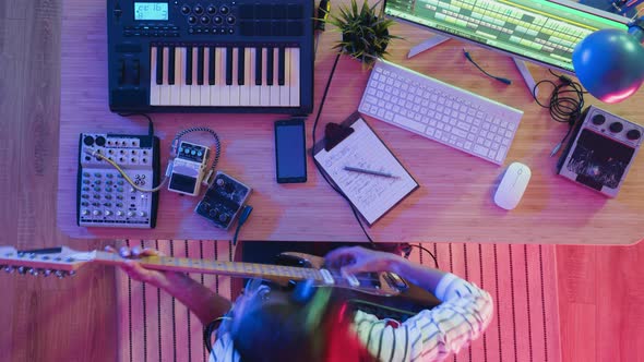 Time Lapse of Female Guitarist Recording Song Playing Electric Guitar at Night in Illuminated Room