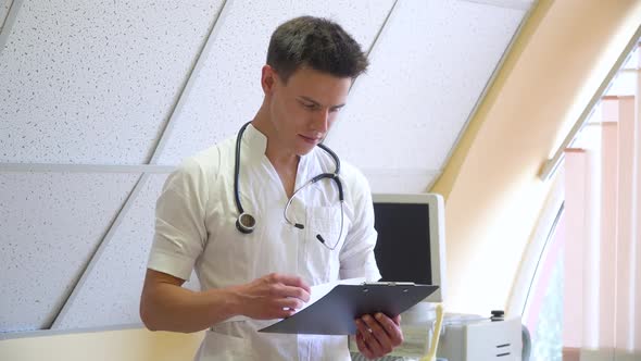 Young Doctor Examines the Patient's Medical History. Concept of Medicine