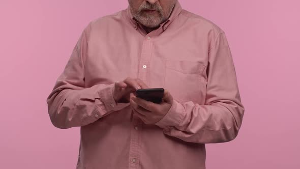 Portrait of an Elderly Man with Glasses Texting on His Phone