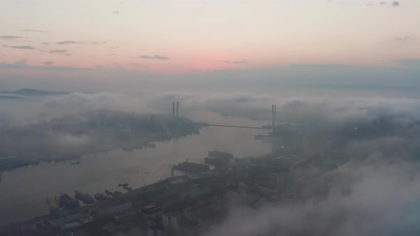 Drone View of the City Bay and Big Bridge Covered with Fog at Sunset