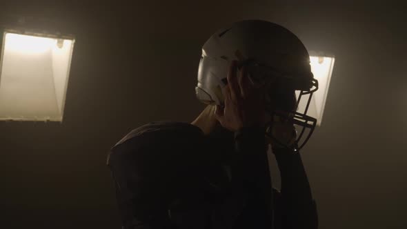 Portrait of a Bearded American Football Player Putting on Helmet and Preparing for Winning Game