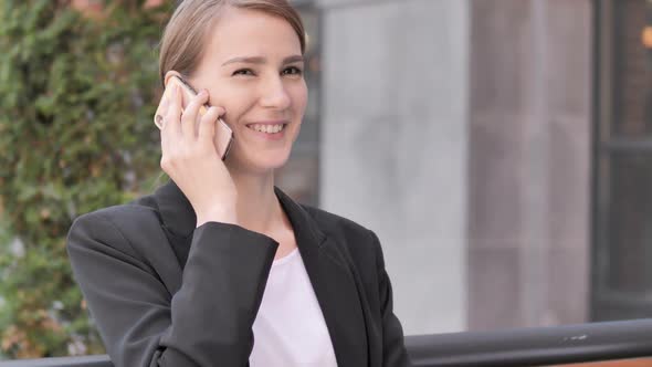 Young Businesswoman Talking on Phone Sitting Outdoor