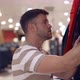 Male Buyer Choosing Warm Clothes in Shopping Center - VideoHive Item for Sale