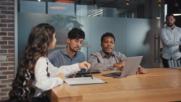 Multiracial Colleagues Sit in Office at Table Discuss Project Ideas Angry Disgruntled Boss Scolds