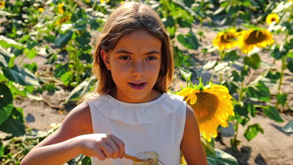 A Child Eats Honey From Flowers