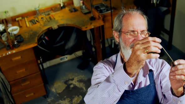 Goldsmith examining metal in workshop