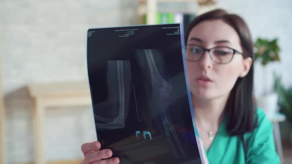 Close Up Woman Doctor with Xray in Hand Communicates with the Patient