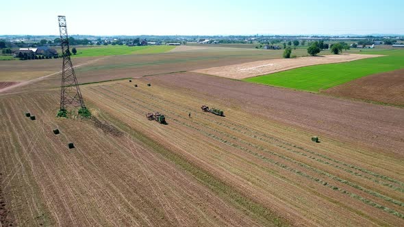 Amish Farm Worker Harvesting the Fields with old and New Equipment