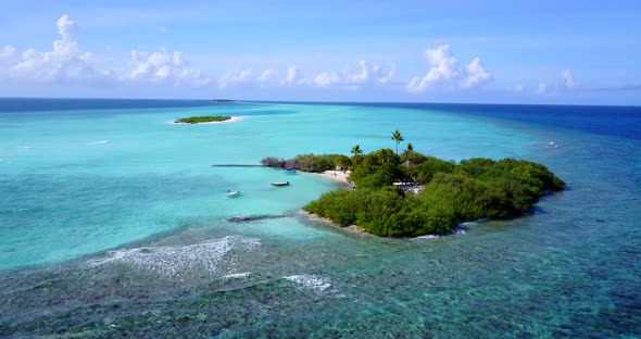 Paradise tropical island with lush vegetation in the edge of great coral reef barrier washed by calm