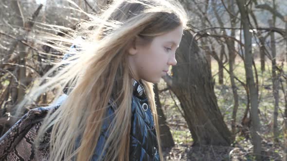 Close Up of Cute Female Child with Backpack Going Along a Trail Near Garden at Early Spring. Small