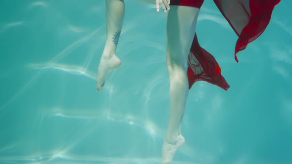 Underwater Shot of Legs Woman Dancing in Red Chiffon Costume