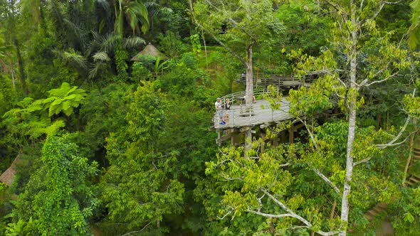 Aerial View Young Couple on the Observation Deck in the Form of a Boat in the Jungle in Bali