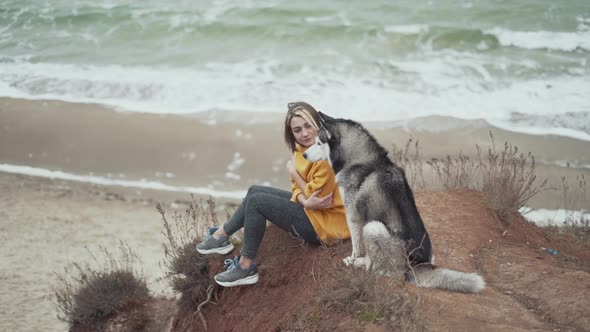 Young Beautiful Female Walking with Siberian Husky Dog on the Beach