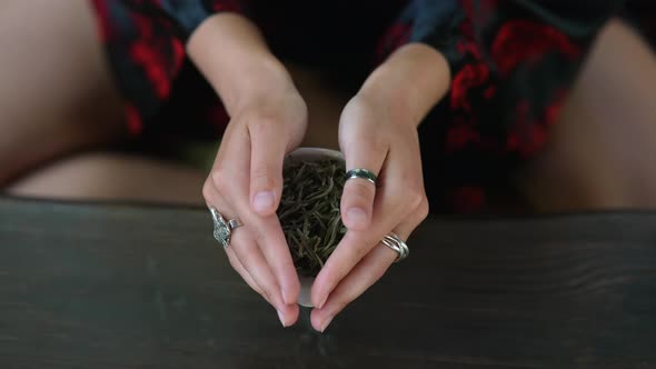 Young Woman Holding a Small Bowl of Green Herbal Tea