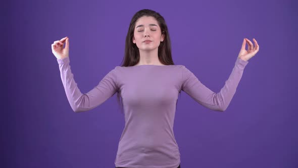 Pretty Young Woman with Closed Eyes Doing Yoga Exercises Meditating with Her Fingers Together