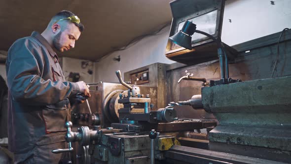 Worker is Measuring a Produced Detail by Caliper