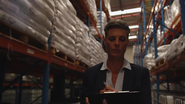 Female manager checks stock in a warehouse 4k