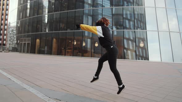 Young Woman Performing Aerial Cartwheel while Doing Parkour Outdoors