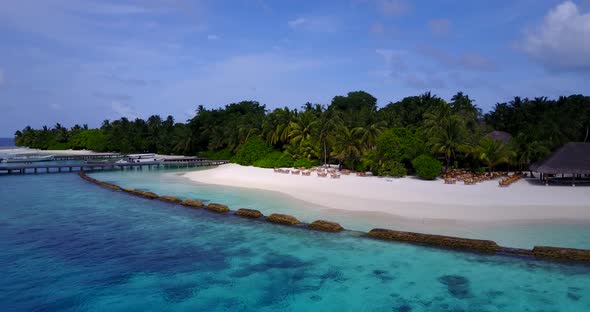 Wide angle above island view of a white sand paradise beach and turquoise sea background 