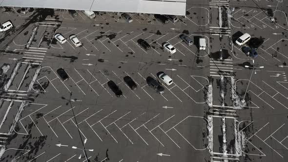 The Car Moves Through an Empty Car Park with Lots of Vacant Parking Spaces  Aerial Drone Shot