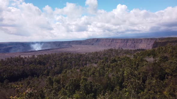 Super wide handheld panning shot of the Kilauea volcano with smoke rising from the cauldron on the B