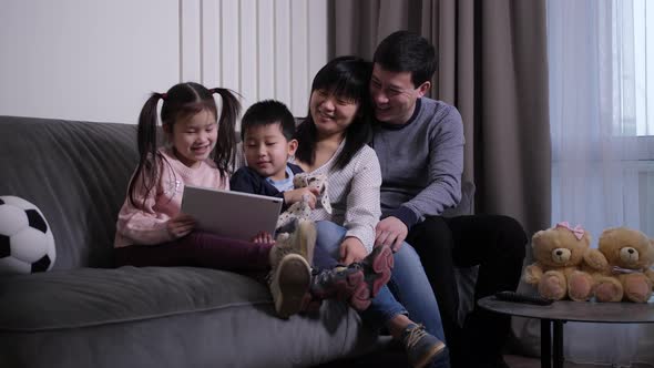 Asian Family Laughing While Watching Video