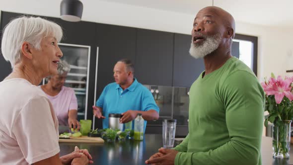 Happy senior diverse people cooking in kitchen at retirement home