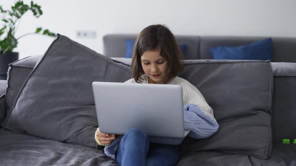 Little School Kid Girl Use Laptop Computer Sitting on Sofa