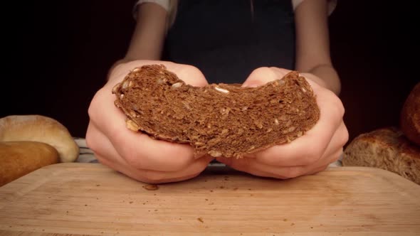 Close Up of Hands Breaking Fresh Rye Bread Loaf Into Halves