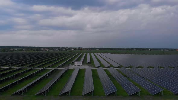 Aerial Drone View Into Large Solar Panels at a Solar Farm at Cloudy Summer Evening. Solar Cell Power