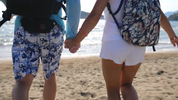 Young Couple Holding Hands and Running Along Beach To Sea. Pair Rejoicing Freedom or Their Summer