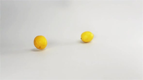 Fresh Yellow Lemons Falling Down on White Surface
