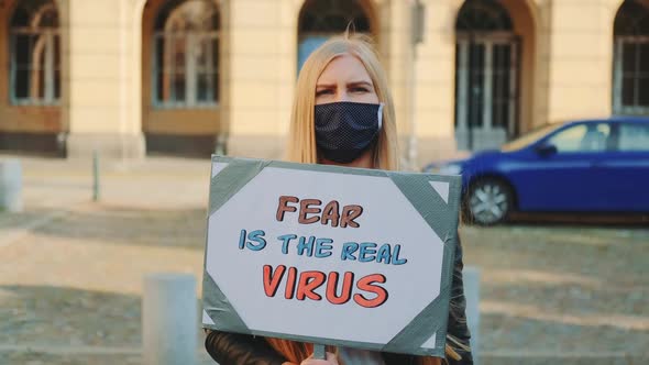 Woman in Mask Protesting That Fear is the Real Virus on Protest March