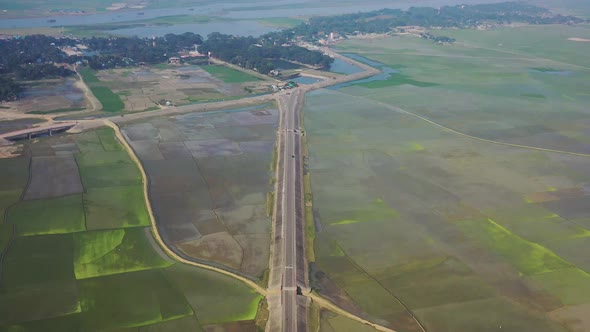 Aerial view of a road among the fields in Sapahar, Rajshahi, Bangladesh.