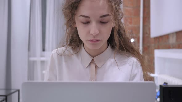 Portrait of Smiling Young Female Sitting and Working on Laptop