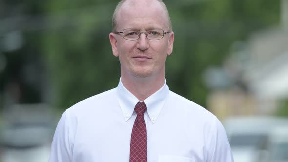 Happy Mature Bald Businessman Smiling Outdoors