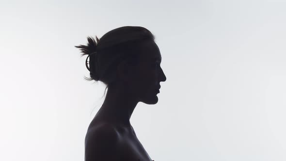 Portrait of a woman in profile raises her head and looks up, double exposure. The silhouette