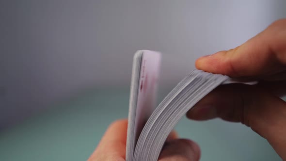 Hands show cardistry with a deck of playing cards, close up