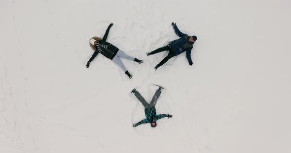 A Group of Young People Depict Snow Angels Lying on the Fresh Snow in the Form of a