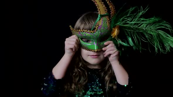 Little Girl in a Green Carnival Mask Looking at the Camera Happy Baby